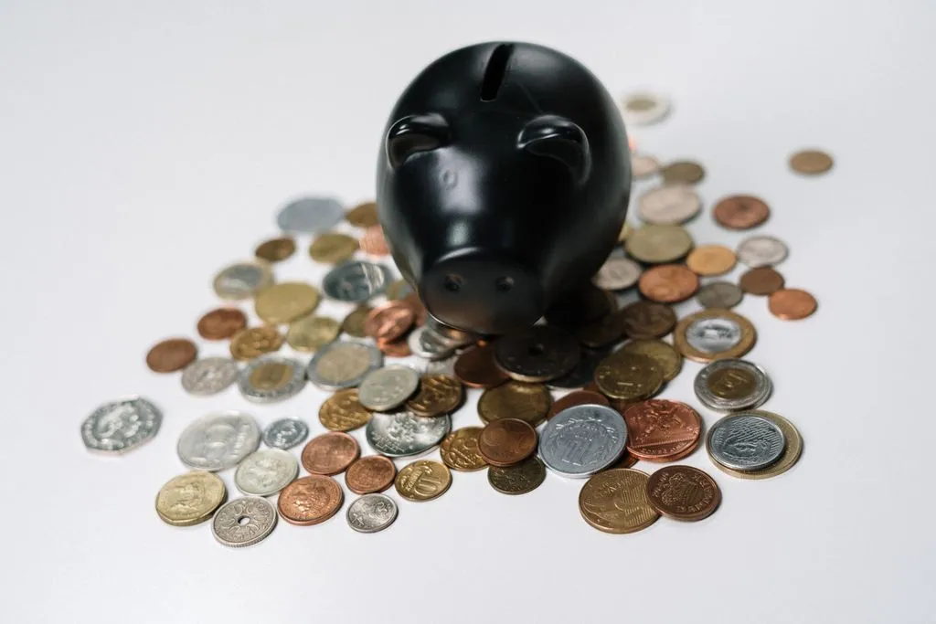 ISA limits and tax on savings Black piggy bank surrounded by British pound and pence coins